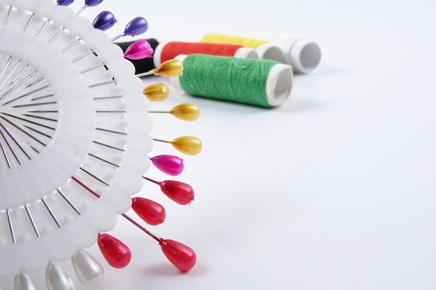 Kolorowe nici i igły ułożone na drewnianym stole